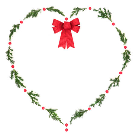 Christmas  heart wreath with fir, red bow and winter holly berries on white. Solstice decorative symbol of love for holiday season, gift tag, invitation, logo, card.の写真素材