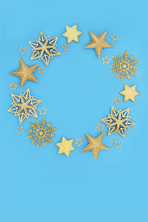 Festive Christmas wreath gold star snowflake bauble decoration on blue background. Holiday season...