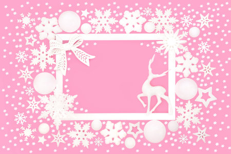 Christmas Eve North Pole reindeer, snowflake, star, bow surreal magical background border on pink, white frame. Frosted decoration design for Yule, Noel, Xmas season.の写真素材