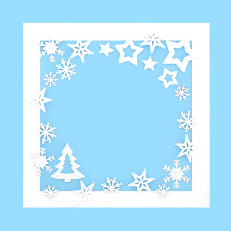 Fantasy Christmas background design with tree stars and snowflakes on blue with white frame. Magical winter wonderland border for the holiday season.の写真素材