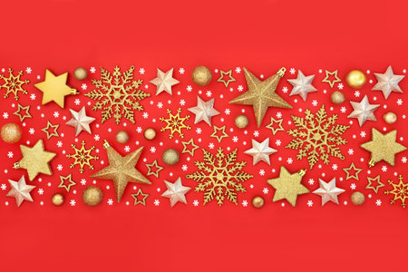 Christmas gold snowflake, star, bulb, decorations and white snowflakes. Background banner on red. Vibrant fantasy festive holiday design for Yule, Xmas, Noel season.の写真素材