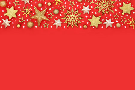 Fantasy Christmas gold snowflake and star tree decorations on red background border. Festive magical seasonal abstract design for the holiday season.の写真素材
