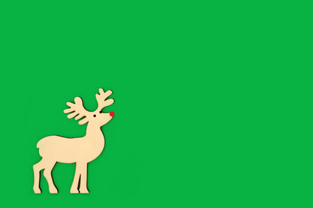 Rudolph the red nose reindeer Christmas Eve Santa helper decoration. on green background. Eco friendly natural  magical symbol concept. Greeting card, gift tag, invitation. Copy space.の写真素材