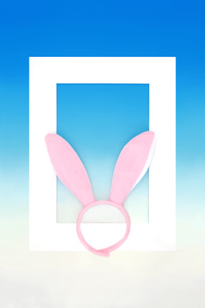 Surreal Easter bunny ears headband design on gradient blue white background with frame. Surrealistic whimsical fun seasonal festive concept.の写真素材