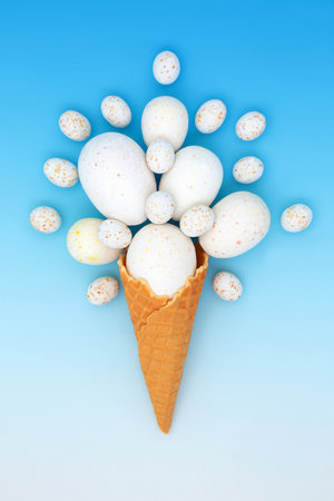 Surreal Easter eggs ice cream cornet design. Fun symbol  for holiday season, logo or greeting card on gradient blue.の写真素材