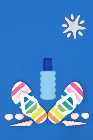 Summer after sun bottle with rainbow flip flops, seashells. Beach items for the holiday season on blue background. Fun abstract starfish sunshine design.の写真素材