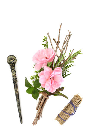 Magic wand, witches herb, twig, rose flower bundle, smudge stick on white. Wicca Pagan and Native American magical equipment for rituals and ceremonies.の写真素材