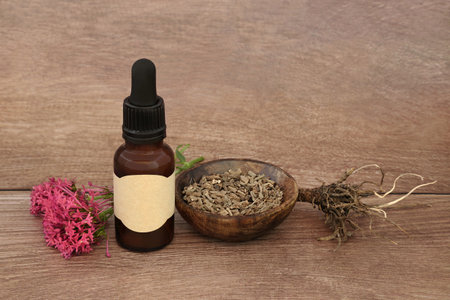 Valerian herb root alternative herbal medicine with tincture bottle, flowers. Used to treat insomnia, stress, anxiety, digestive health, menstrual cramps. Natural healing.の写真素材