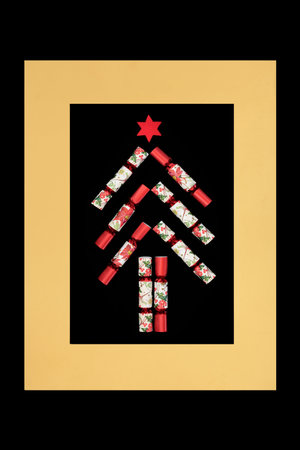 Christmas cracker abstract tree shape design in red white colors on black, gold border background frame. Festive design for holiday season for logo, Xmas card.の写真素材