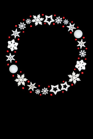 Christmas wreath red holly berries, white snowflake, star, ball shape decorations on white background. Frosted bauble garland design for Xmas season.の写真素材