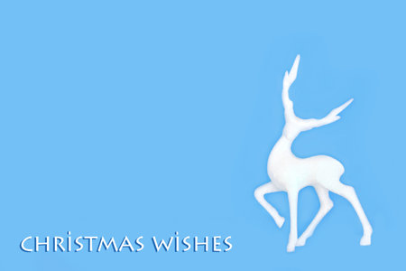Christmas wishes magical reindeer tree decoration on blue background with text. Fantasy festive mythological creature for the holiday season. Copy space.の写真素材