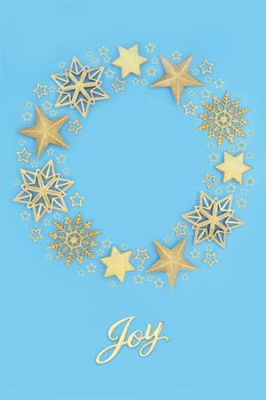 Glad tidings of joy sign with festive Christmas wreath, gold star, snowflake bauble decorations on blue. Festive concept for the New Year and Xmas holiday season.の写真素材