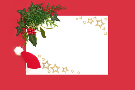 Santa hat Christmas decoration, gold stars, winter nature flora, holly berries, mistletoe, ivy, fir on white red background border frame. Festive design.の写真素材