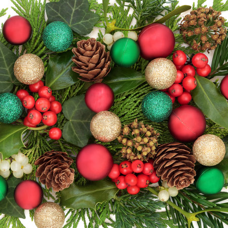 Christmas festive nature background with bauble decorations, holly, mistletoe berries, ivy, fir, pine cones. Xmas flora design for holiday season on white.の写真素材