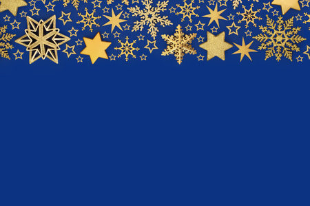 Xmas luxury bauble decorations gold stars, snowflakes, background on blue. Festive abstract design for holiday Christmas season. Greeting card.の写真素材