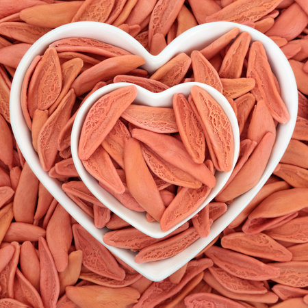 Romantic Italian foglie D'Ulivo pasta background with heart shape bowls. Dried olive leaf shape vegetarian carbohydrate food dyed red with tomato.の写真素材