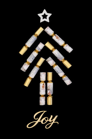 Christmas crackers abstract tree shape design with gold Joy sign on black background. Festive whimsical seasonal design for holiday season, logo, Xmas card.の写真素材