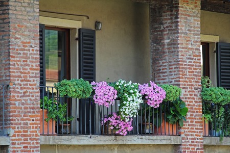 Typical classical Italian house balcony with blooming flowers. Verona, Italy.の写真素材