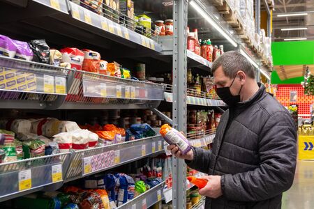 A masked man buys food at the Lenta chain store during the covid19 pandemic.の写真素材