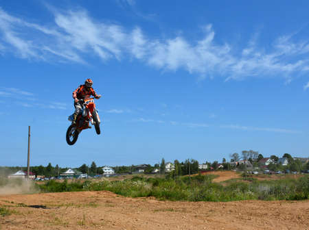 A motorcyclist on a motocross bike makes a jump on a motorcycle