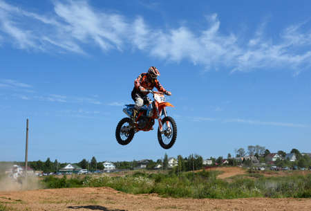 A motorcyclist on a motocross bike makes a jump on a motorcycle