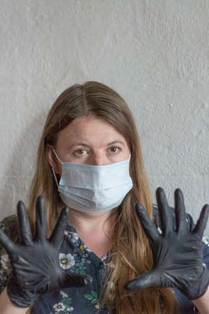 A young woman wearing a mask and gloves during the pandemic.の写真素材