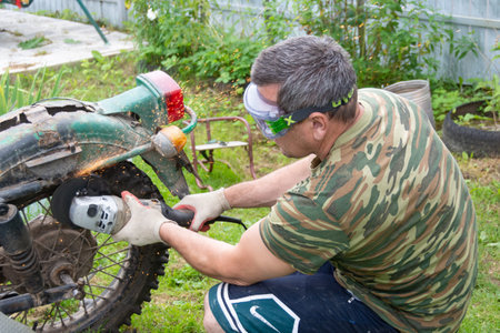 Repairs of an old motorcycle "Ural" in the summer in warm weather in the countryのeditorial素材