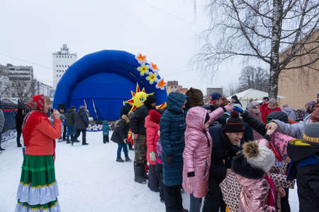 Maslenitsa 2021. Traditional street festivities. Adults and children play outdoor games on the street at a festive event. Moscow region, Russia.のeditorial素材