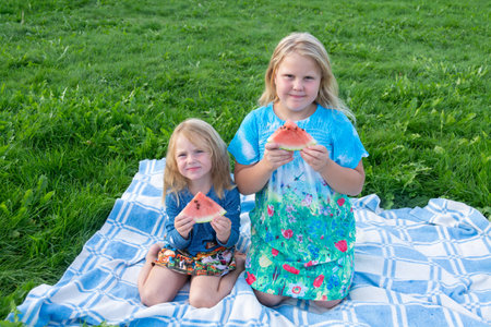 Children enjoy eating delicious, red, ripe, juicy, appetizing watermelonの写真素材