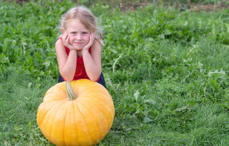 Autumn. Harvesting. A girl and a pumpkin.の写真素材