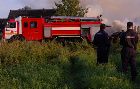 Fire service officers arrived at the scene. A fire truck at the scene of the fire. A fire in the village. Burning wooden houses in the village of Rantsevo, Tver region.のeditorial素材