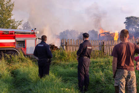 Police officers arrived at the scene. A fire in the village. Burning wooden houses in the village of Rantsevo, Tver region.のeditorial素材