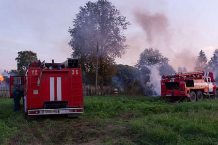Fire service officers arrived at the scene. A fire truck at the scene of the fire. A fire in the village. Burning wooden houses in the village of Rantsevo, Tver region.のeditorial素材