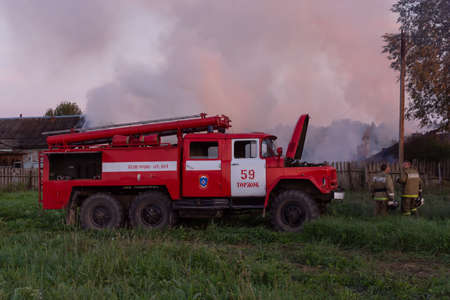 Fire service officers arrived at the scene. A fire truck at the scene of the fire. A fire in the village. Burning wooden houses in the village of Rantsevo, Tver region.のeditorial素材