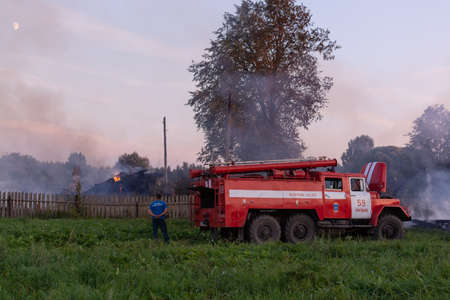 Fire service officers arrived at the scene. A fire truck at the scene of the fire. A fire in the village. Burning wooden houses in the village of Rantsevo, Tver region.のeditorial素材