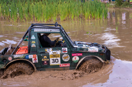 The car overcomes difficult obstacles. Large-scale sports competitions of off-road cars "TVER KNEADING: RACE OF TITANS" in the "Pavlov Adventure Park" in Tver. August 12, 2022.のeditorial素材