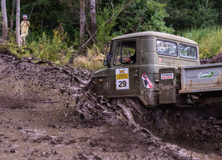 The car overcomes difficult obstacles. Large-scale sports competitions of off-road cars "TVER KNEADING: RACE OF TITANS" in the "Pavlov Adventure Park" in Tver. August 12, 2022.のeditorial素材