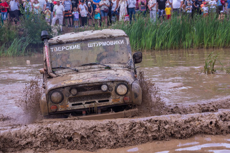 The car overcomes difficult obstacles. Large-scale sports competitions of off-road cars "TVER KNEADING: RACE OF TITANS" in the "Pavlov Adventure Park" in Tver. August 12, 2022.のeditorial素材