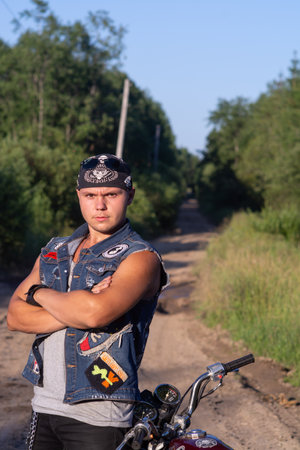 Portrait of a young man with a motorcycle on the street.の写真素材