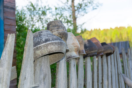 Old wooden objects hanging on a fence in a rural garden.の写真素材