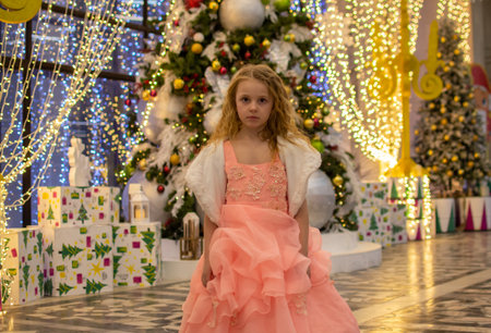 A beautiful elegant girl near the Christmas tree in the New Year. Holiday. New Year. The child is a model.の写真素材