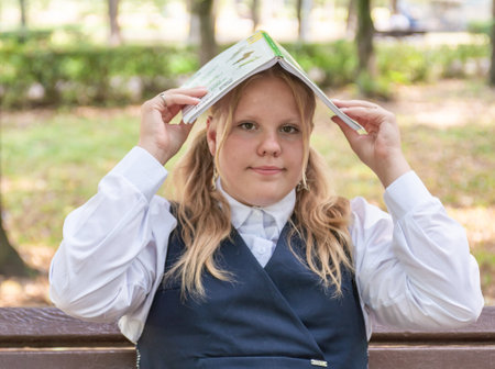 Knowledge day. The first of September. A beautiful elegant girl with a fashionable hairstyle in a school uniform in the park. Schoolgirl. Schoolgirl. September 2024.の写真素材