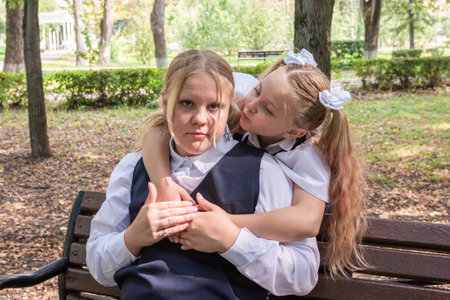 Knowledge day. The first of September. Beautiful elegant girls with fashionable hairstyle in school uniform in the park. Schoolgirl. Schoolgirl. September 2024.の写真素材