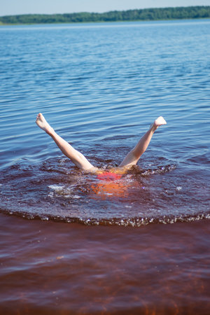 A girl with pink hair is relaxing on a lake on a hot summer day.の写真素材