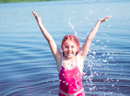 A girl with pink hair is relaxing on a lake on a hot summer day.の写真素材