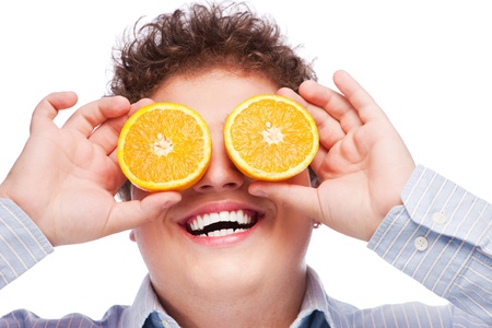 Happy man with slices of orange on his eyes, isolated on white backgroundの写真素材