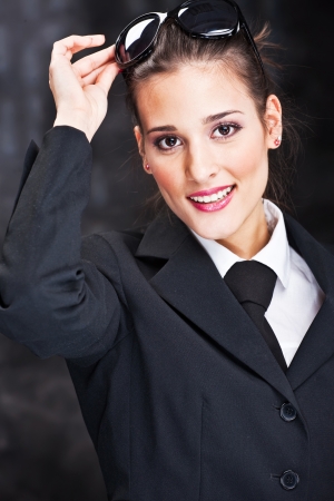 Pretty woman with sun glasses on dark backgroundの写真素材
