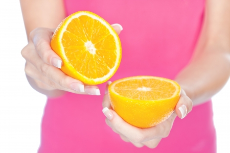 woman's hands holding two slice of orangeの写真素材