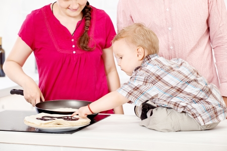 happy family makes pancakes in the kitchenの写真素材