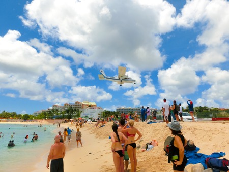 Philipsburg, Sint Maarten, Netherlands - May 14, 2016: The beach at Maho Bay is one of the world's premier planespotting destinations. Airplanes landing at the Princess Juliana Airport fly over beachgoers.のeditorial素材